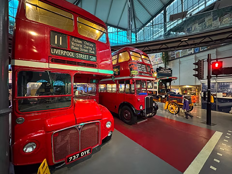 На передньому плані класичний лондонський даблдеккер моделі Routemaster. Цей конкретний екземпляр вироблений 1963 року. Докладніше про цей автобус: [www.ltmuseum.co.uk](https://www.ltmuseum.co.uk/collections/collections-online/vehicles/item/1991-23-part-0)